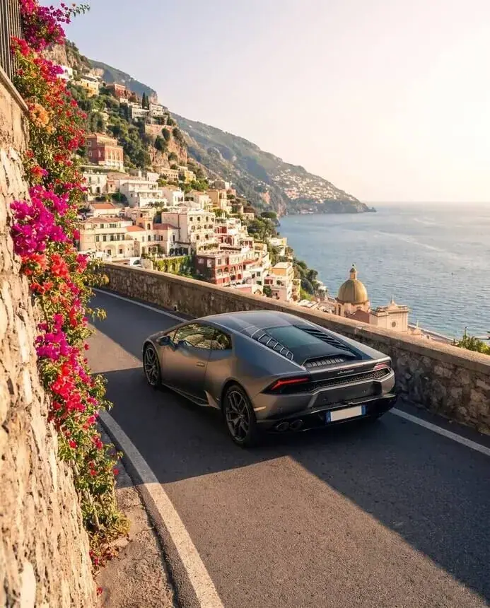 Car campaign frame: sports car on the Amalfi coast road, bougainvillea